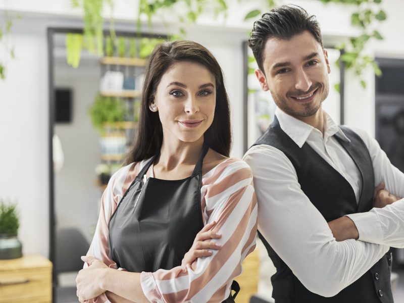 Portrait of smiling hairstylist and his assistant